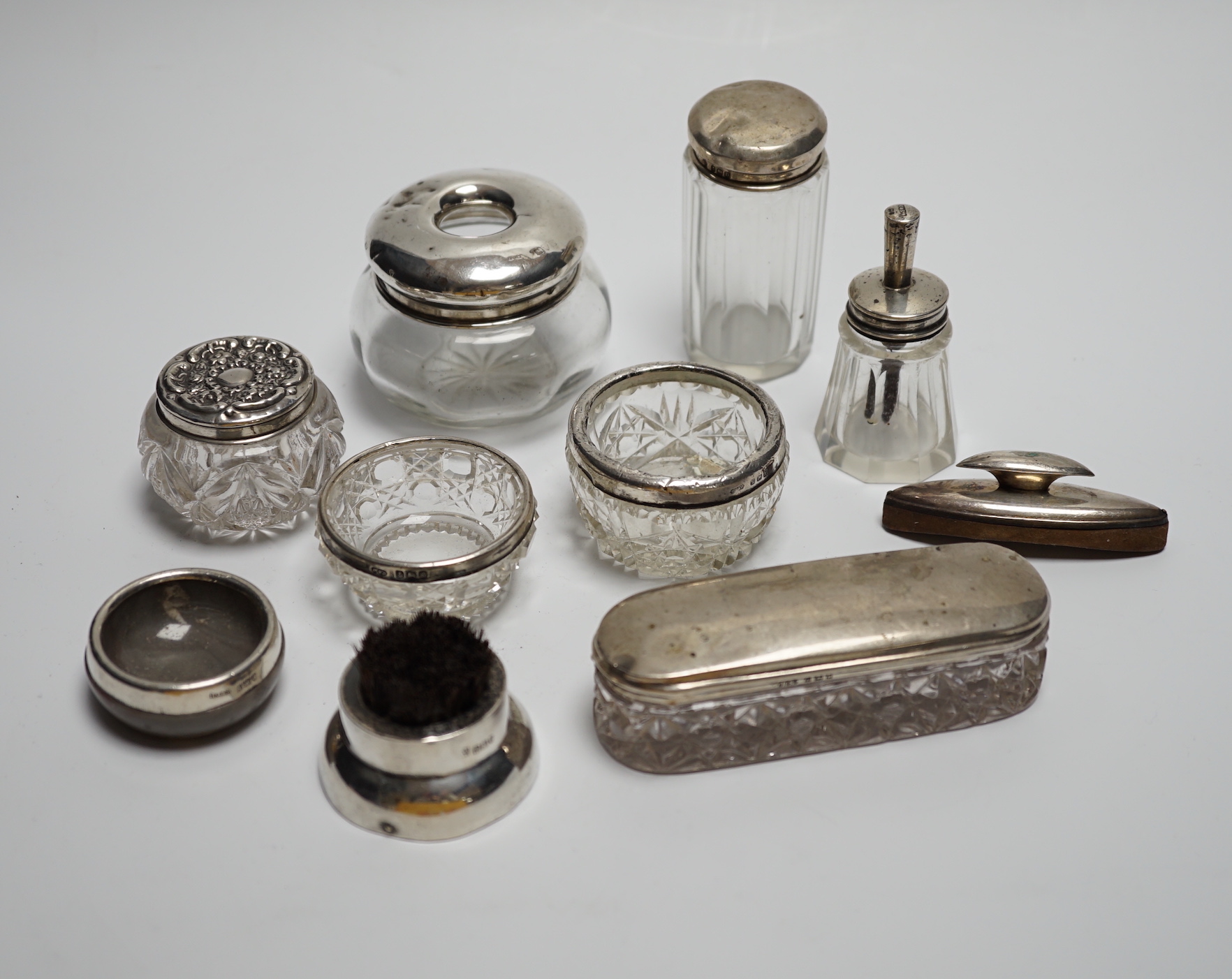 Eight assorted silver topped toilet jars, a silver mounted nail buffer and pen wipe.